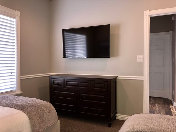 White Sage Recovery guest room with a dresser and television